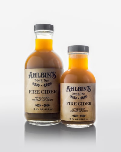 Two bottles of amber liquid labelled Ahlbin's Tried and True Fire Cider